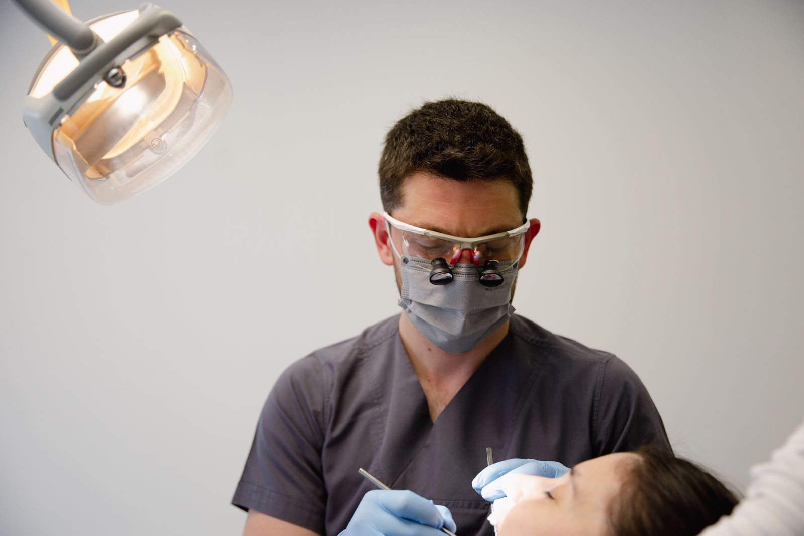 Dentista atendendo paciente com atenção em consultório