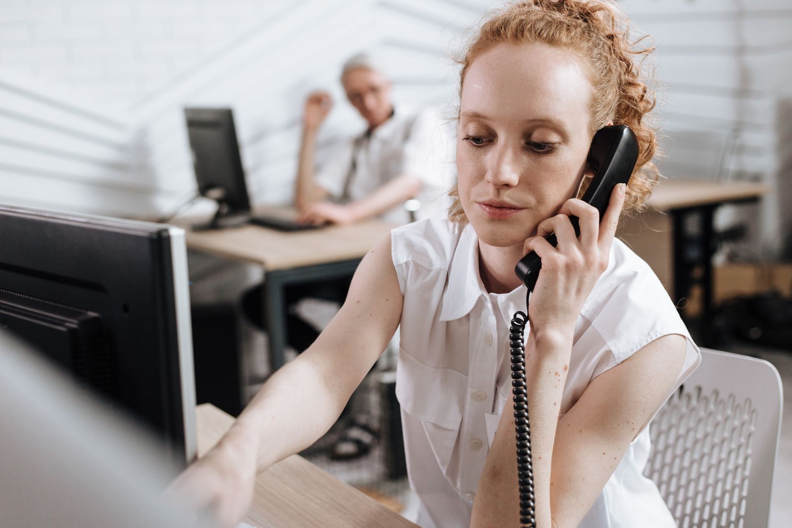 Recepcionista atendendo telefone em clínica